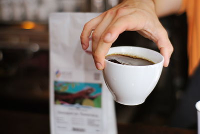 Midsection of person holding coffee cup