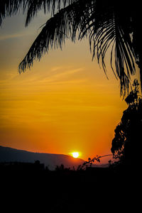 Scenic view of silhouette landscape against orange sky