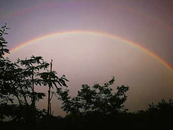 Low angle view of rainbow against sky at sunset