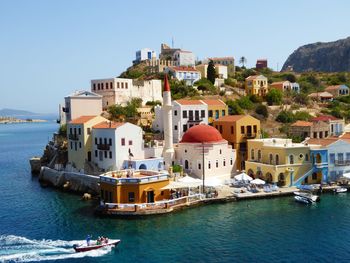 Boats in sea with buildings in background