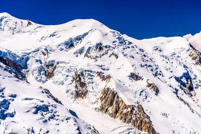 Scenic view of snowcapped mountains against clear sky