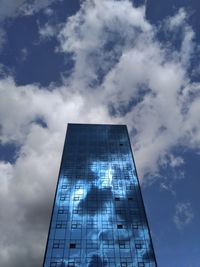 Low angle view of modern building against cloudy sky