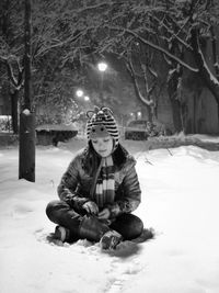 Cute girl sitting on snow at night