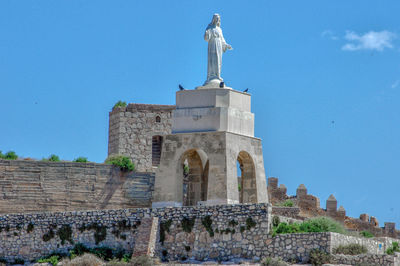 Low angle view of historical building against blue sky