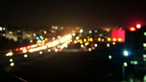 Defocused lights against sky at night