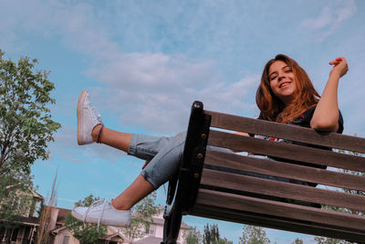 Portrait of happy young woman against sky