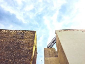 Low angle view of buildings against cloudy sky