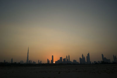 Silhouette of buildings against sky during sunset