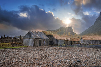 Abandoned houses surrounded by wooden fence under vestrahorn mountain at sunset