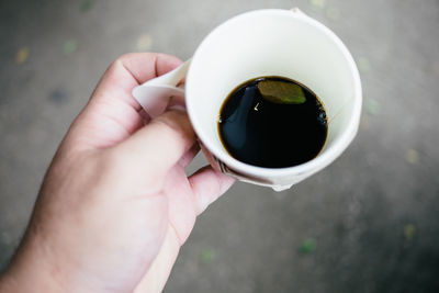 Close-up of hand holding coffee cup