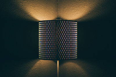 Close-up of illuminated sconce light on wall