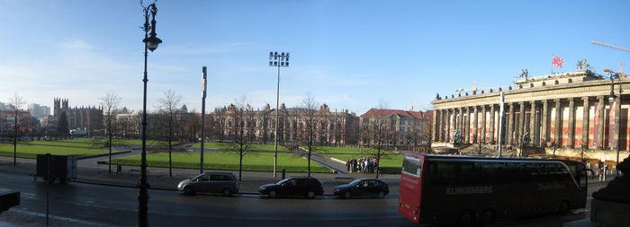 Cars on city street against sky