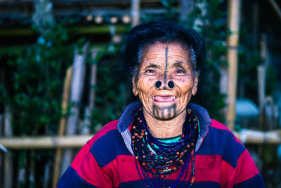 Apatani tribal women facial expression with her traditional nose lobes and blurred background