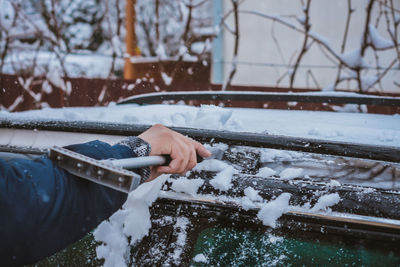 Person holding ice cream cone during winter