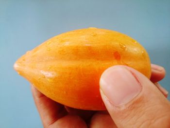 Close-up of hand holding orange