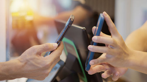 Cropped hands of woman using mobile phone