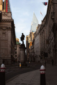 Statue in city against sky