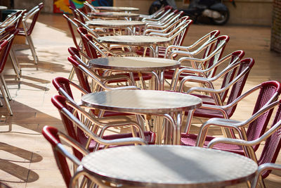 Empty chairs and tables at sidewalk cafe