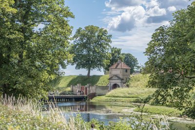 Arch bridge over river against sky