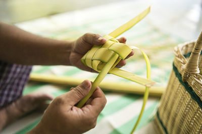 Weaving the coconut leaves making the ketupat, a traditional malay cuisine for the eid celebration.