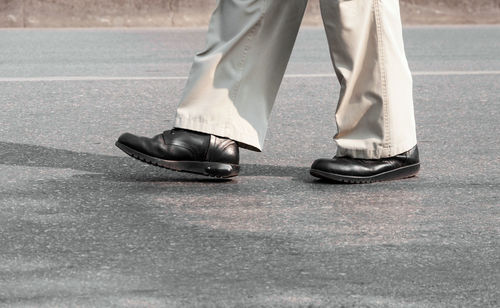 Low section of man standing on street