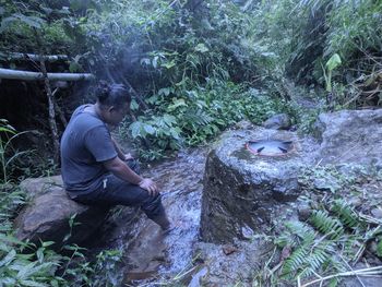 Full length of man by waterfall in forest