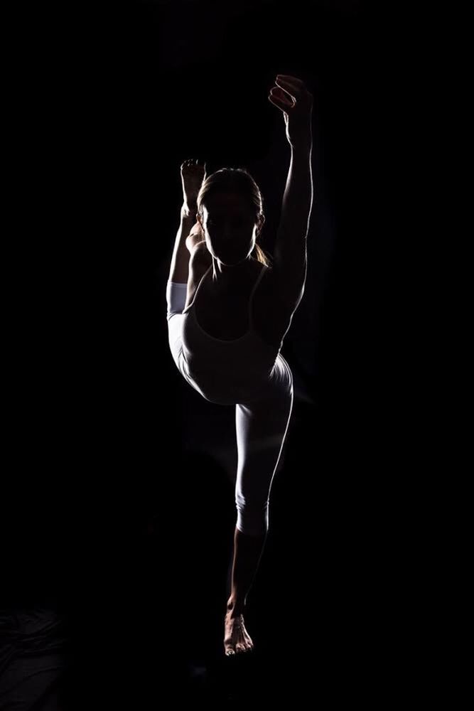 black background, studio shot, full length, limb, arms raised, human arm, motion, skill, ballet, flexibility, grace, one person, balance, ballet dancer, concentration, agility, strength, performance, sports clothing, dancer, young adult, human body part, adult, one woman only, one young woman only, adults only, sport, illuminated, only women, people, legs apart, athlete, night