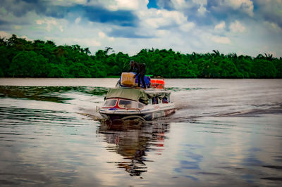 Man on boat in river against sky
