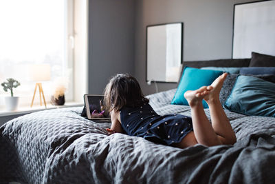 Woman lying on bed in bedroom