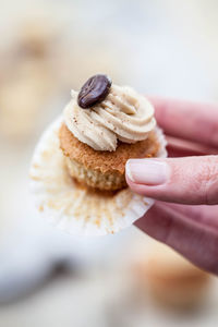 Cropped image of hand holding cupcake