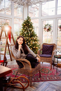 Portrait of woman sitting on chair at home