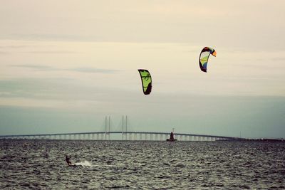 People paragliding over sea against sky