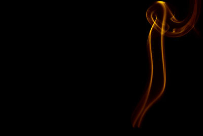 Orange smoke against black background