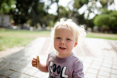 Portrait of cute boy holding ice cream outdoors