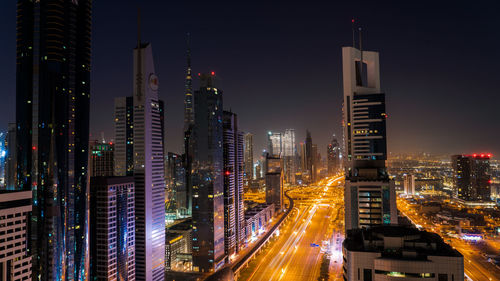 Illuminated buildings in city at night, sheikh zayed road, dubai