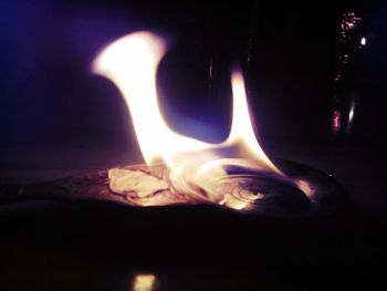 Close-up of lit candle in dark room