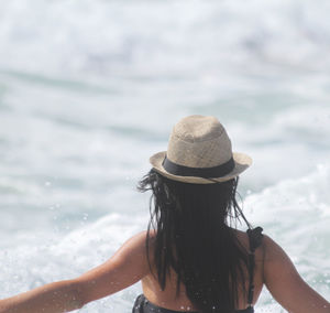 Rear view of woman wearing hat at sea