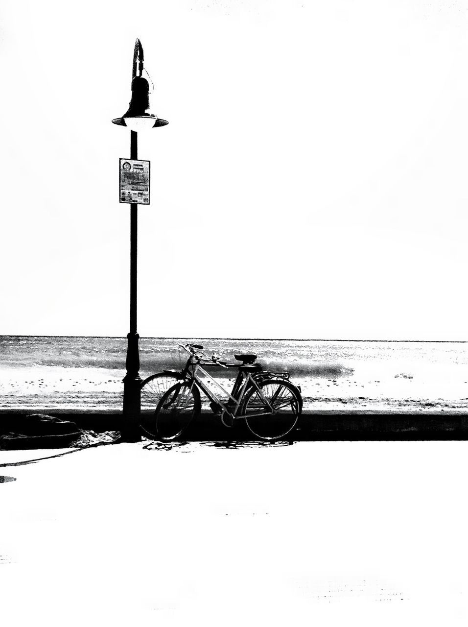 clear sky, copy space, street light, transportation, pole, bicycle, tranquility, day, outdoors, nature, no people, low angle view, lighting equipment, mode of transport, guidance, horizon over water, beach, sea, safety, tranquil scene