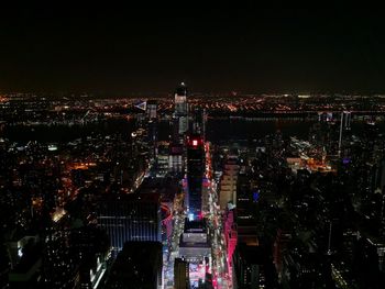 Illuminated cityscape against sky at night