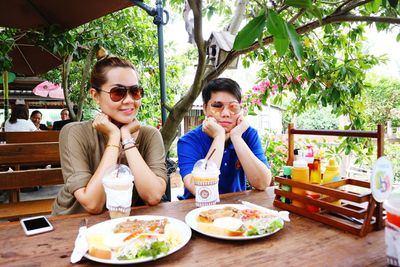 Portrait of a smiling young woman sitting at restaurant table