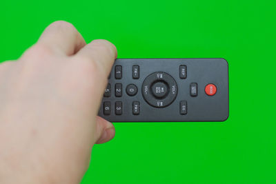 Cropped hand holding remote control