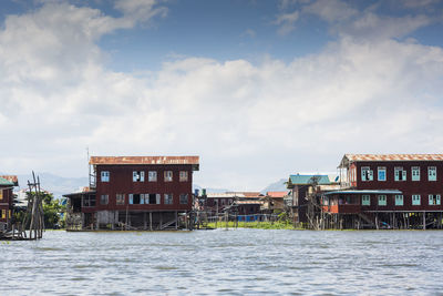 Buildings by sea against sky