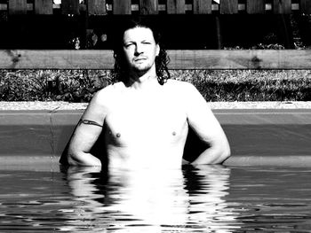 Portrait of young man standing in swimming pool