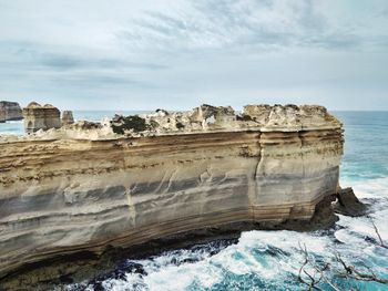 Scenic view of rock formation by sea against sky