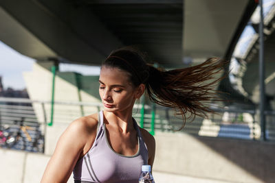 Close-up of young woman tossing hair