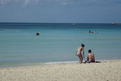 People at beach against sky