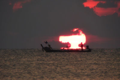 Silhouette boat in sea against sky at sunset