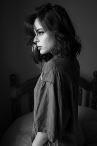 Young woman looking away against wall