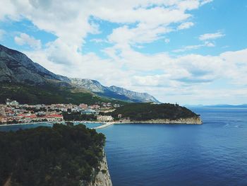 Scenic view of sea by town against sky