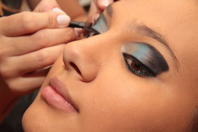 Close-up of beautician applying make-up on woman